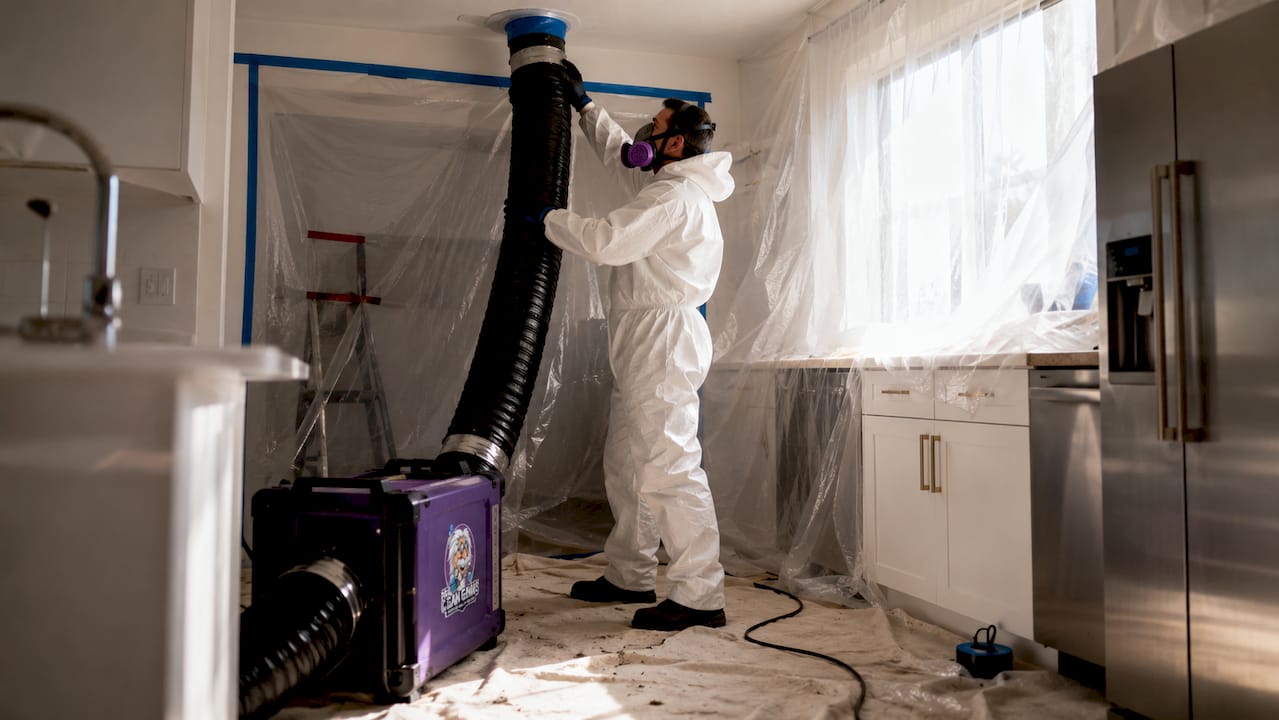 Technician setting up negative air machine in sealed room