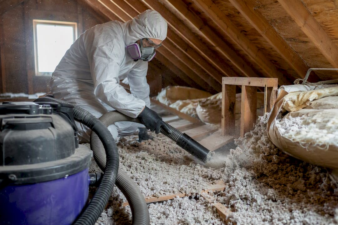 Installer removing attic insulation