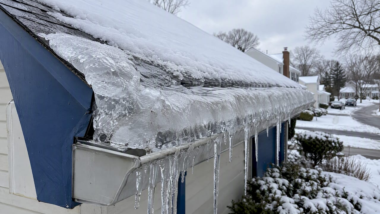 Ice dam ridge along a snow-covered roof edge